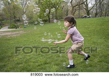 A young girl catching bubbles in Central Park, New York City View Large Photo Image Stock Image - A young girl catching bubbles in Central Park, New York City. Fotosearch