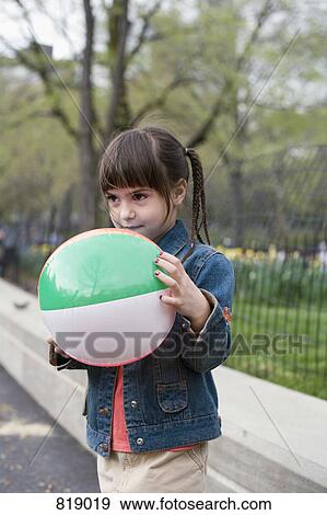 A young girl holding an inflatable ball in Central Park, New York City View Large Photo Image Stock Photo - A young girl holding an inflatable ball in Central Park, New York City. Fotosearch