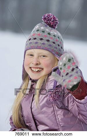 A young girl in winter clothing waving, outdoors View Large Photo Image Stock Image - A young girl in winter clothing waving, outdoors. Fotosearch