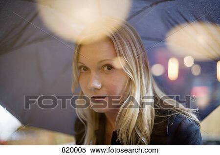 A young woman holding an umbrella and looking through a window View Large Photo Image Stock Photography - A young woman holding an umbrella and looking through a window. Fotosearch
