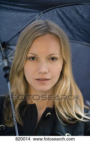 A young woman holding an umbrella View Large Photo Image Picture - A young woman holding an umbrella. Fotosearch