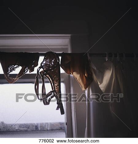 Stock Image - Bras and panties hanging from a shower curtain rod. Fotosearch
