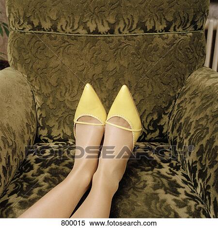 Detail of a woman wearing high heel shoes and with her feet up on an armchair View Large Photo Image Stock Photography - Detail of a woman wearing high heel shoes and with her feet up on an armchair. Fotosearch
