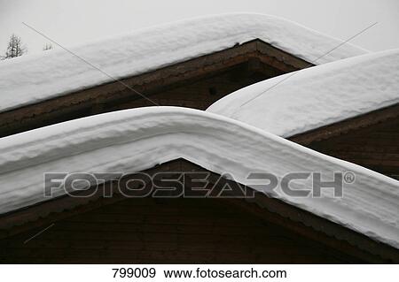 Stock Photo - Detail of snow on the roof of a log cabin, Graubuenden, Switzerland. Fotosearch