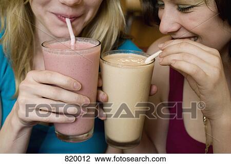 Detail of two young women drinking fruit smoothies View Large Photo Image Stock Image - Detail of two young women drinking fruit smoothies. Fotosearch