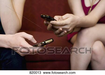 Detail of two young women using mobile phones View Large Photo Image Stock Image - Detail of two young women using mobile phones. Fotosearch