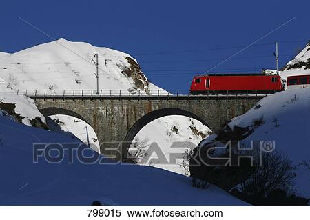 Glacier Express train crossing bridge over snowy mountains, Graubuenden, Switzerland View Large Photo Image Stock Photography - Glacier Express train crossing bridge over snowy mountains, Graubuenden, Switzerland. Fotosearch