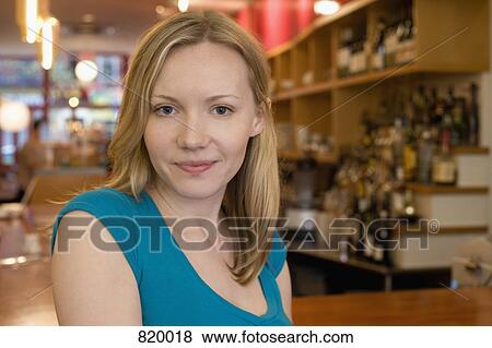 Portrait of a young woman smiling in a cafe View Large Photo Image Stock Photo - Portrait of a young woman smiling in a cafe. Fotosearch