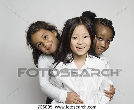 Stock Photography - Portrait of three girls embracing each other. Fotosearch