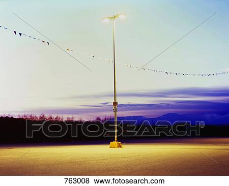 Street lights above an empty parking lot View Large Photo Image Stock Photo - Street lights above an empty parking lot. Fotosearch