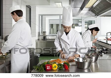 Three chefs working in a commercial kitchen View Large Photo Image Stock Photo - Three chefs working in a commercial kitchen. Fotosearch
