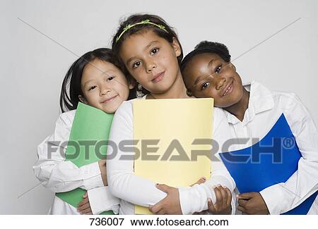 Stock Photo - Three girls holding multi colored paper. Fotosearch