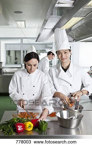 Two chefs doing prep work in a commercial kitchen View Large Photo Image Stock Image - Two chefs doing prep work in a commercial kitchen. Fotosearch