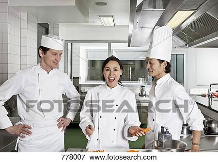 Two chefs teasing another chef View Large Photo Image Stock Photo - Two chefs teasing another chef. Fotosearch