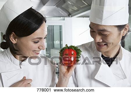 Two chefs with a bell pepper with a face on it View Large Photo Image Stock Image - Two chefs with a bell pepper with a face on it. Fotosearch