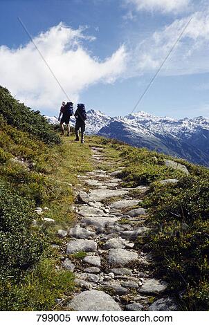 Two people hiking up a mountain path, Valais, Switzerland View Large Photo Image Stock Photography - Two people hiking up a mountain path, Valais, Switzerland. Fotosearch