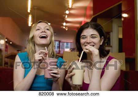 Two young women drinking fruit smoothies View Large Photo Image Stock Photo - Two young women drinking fruit smoothies. Fotosearch
