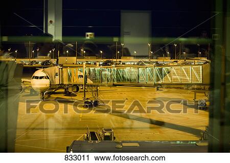 A passenger boarding bridge connected to an airplane View Large Photo Image Stock Image - A passenger boarding bridge connected to an airplane. Fotosearch