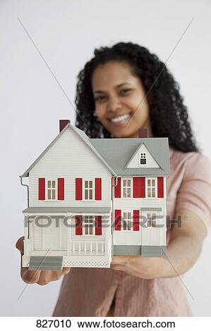 A woman holding a miniature house View Large Photo Image Stock Image - A woman holding a miniature house. Fotosearch