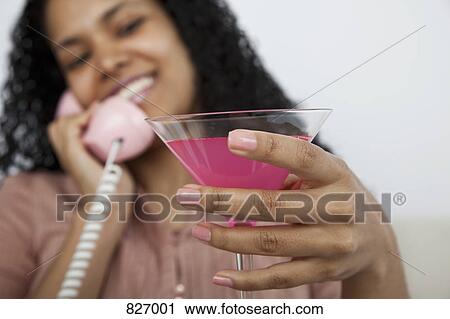 A woman holding a pink cocktail View Large Photo Image Stock Image - A woman holding a pink cocktail. Fotosearch