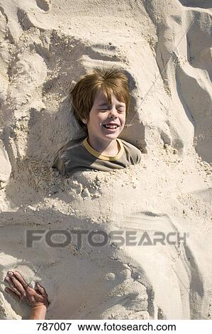 A young boy buried in sand, Cable Beach, Nassau, Bahamas, Caribbean View Large Photo Image Stock Photo - A young boy buried in sand, Cable Beach, Nassau, Bahamas, Caribbean. Fotosearch