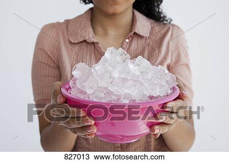 Stock Image - Detail of a woman holding a bowl of ice. Fotosearch