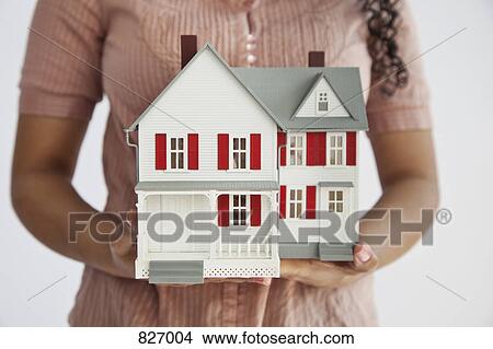Midsection of a woman holding a miniature house View Large Photo Image Picture - Midsection of a woman holding a miniature house. Fotosearch