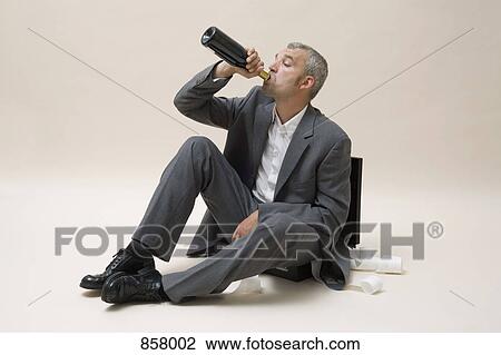 A businessman drinking a bottle of wine View Large Photo Image Stock Image - A businessman drinking a bottle of wine. Fotosearch