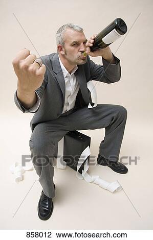 A businessman drinking a bottle of wine and holding up his fist View Large Photo Image Stock Image - A businessman drinking a bottle of wine and holding up his fist. Fotosearch