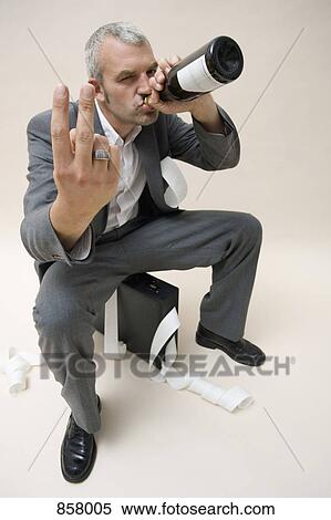A businessman drinking a bottle of wine and gesturing View Large Photo Image Stock Photography - A businessman drinking a bottle of wine and gesturing. Fotosearch