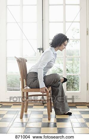 A businesswoman stretching on a chair View Large Photo Image Picture - A businesswoman stretching on a chair. Fotosearch