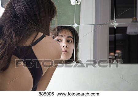 A woman putting on make-up, rear view View Large Photo Image Stock Photograph - A woman putting on make-up, rear view. Fotosearch