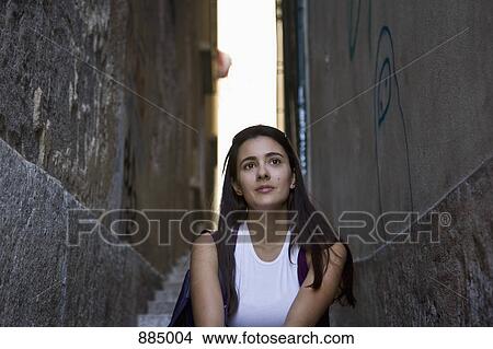 A woman sitting on steps between two buildings, day dreaming View Large Photo Image Picture - A woman sitting on steps between two buildings, day dreaming. Fotosearch