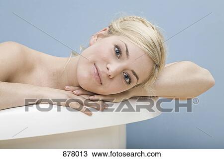 A woman with her head resting on her arm on the edge of a tub View Large Photo Image Stock Image - A woman with her head resting on her arm on the edge of a tub. Fotosearch