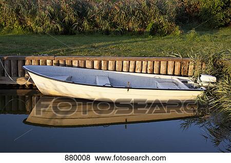 An outboard motor fishing boat moored at an embankment View Large Photo Image Stock Photo - An outboard motor fishing boat moored at an embankment. Fotosearch