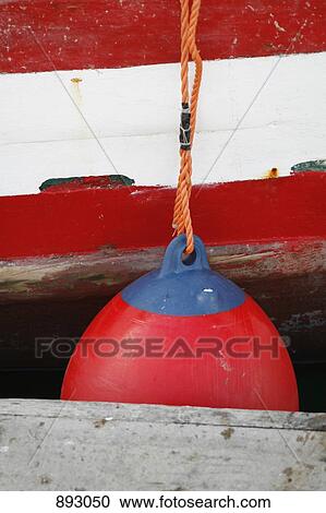 Stock Image - A boat bumper tied to a boat docked at a jetty. Fotosearch