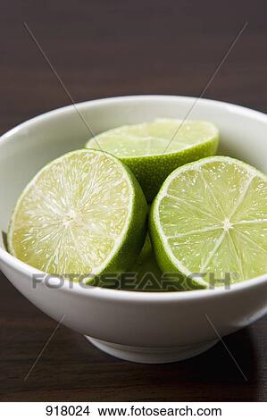 Picture - A bowl of halved limes . Fotosearch
