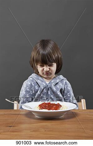A boy looking down at a bowl of spaghetti in disgust, studio shot View Large Photo Image Stock Image - A boy looking down at a bowl of spaghetti in disgust, studio shot. Fotosearch