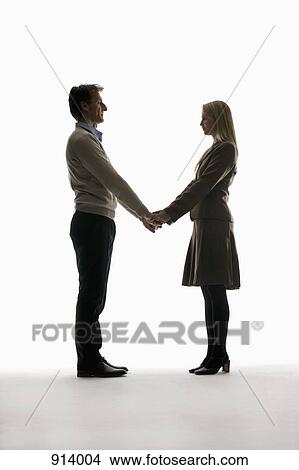 Picture - A boyfriend and girlfriend holding hands, face to face. Fotosearch