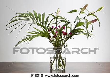 A bunch of Easter lilies and Gomphrena flowers in a vase View Large Photo Image Stock Photo - A bunch of Easter lilies and Gomphrena flowers in a vase. Fotosearch