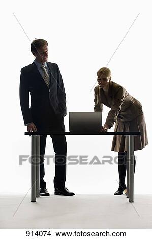 A businesswoman and businessman working together with a laptop View Large Photo Image Picture - A businesswoman and businessman working together with a laptop. Fotosearch