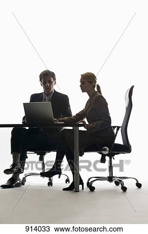 A businesswoman and businessman working together with a laptop View Large Photo Image Stock Image - A businesswoman and businessman working together with a laptop. Fotosearch