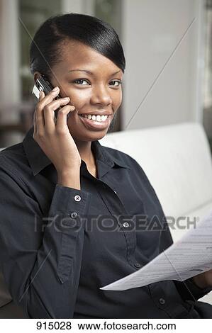 Stock Photo - A businesswoman using a mobile phone. Fotosearch