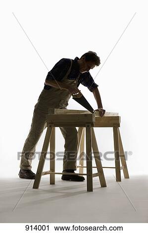 A carpenter sawing a wooden plank View Large Photo Image Stock Image - A carpenter sawing a wooden plank. Fotosearch