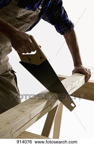 A carpenter sawing a wooden plank, focus on saw View Large Photo Image Stock Photograph - A carpenter sawing a wooden plank, focus on saw. Fotosearch