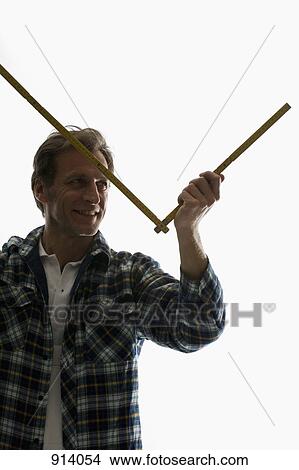 A carpenter using a folding ruler View Large Photo Image Picture - A carpenter using a folding ruler. Fotosearch