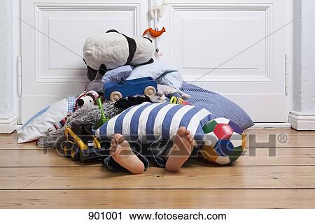Stock Image - A child covered in toys, only feet visible. Fotosearch