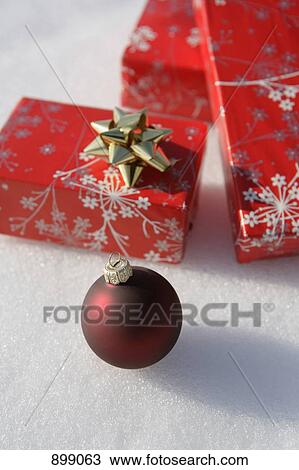 A Christmas ornament and Christmas presents on the snow View Large Photo Image Stock Image - A Christmas ornament and Christmas presents on the snow. Fotosearch