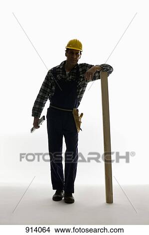 A construction worker carrying a level and leaning on a plank View Large Photo Image Picture - A construction worker carrying a level and leaning on a plank. Fotosearch
