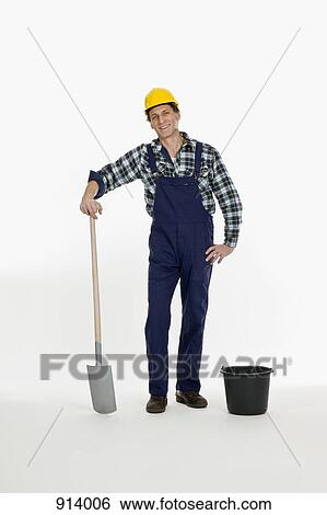 Stock Photograph - A construction worker posing with a shovel and bucket. Fotosearch